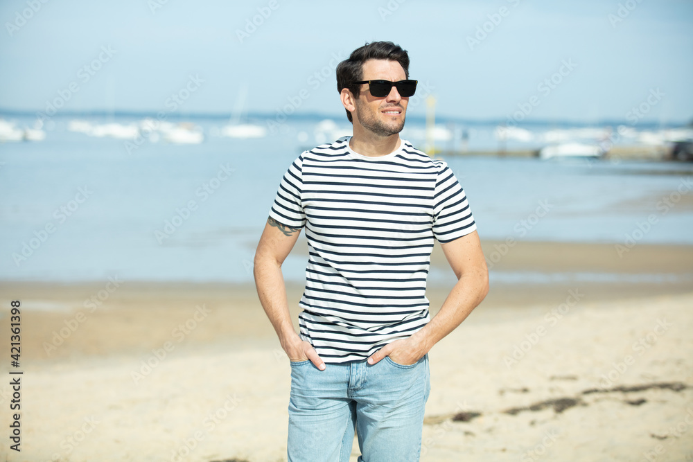 handsome man with sunglasses enjoying day on the beach