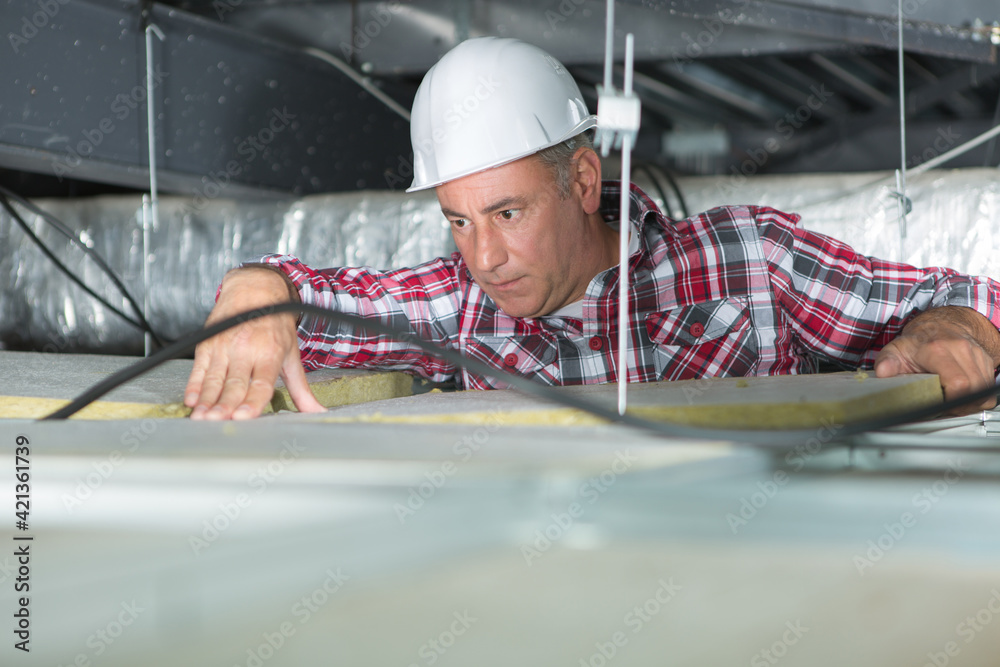 electrical maintenance worker checking the cables on the ceiling electrical maintenance worker checking the cables on the ceiling