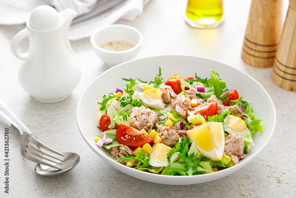 Tuna salad with boiled egg, tomato, lettuce, corn and red onion. Healthy and detox food concept. Ketogenic diet. Fresh vegetable salad bowl on white background Tuna salad with boiled egg, tomato, lettuce, corn and red onion. Healthy and detox food concept. Ketogenic diet. Fresh vegetable salad bowl on white background