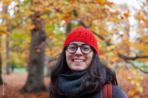 person in autumn park,woman in red hat smiling, woman in an autumn forest
