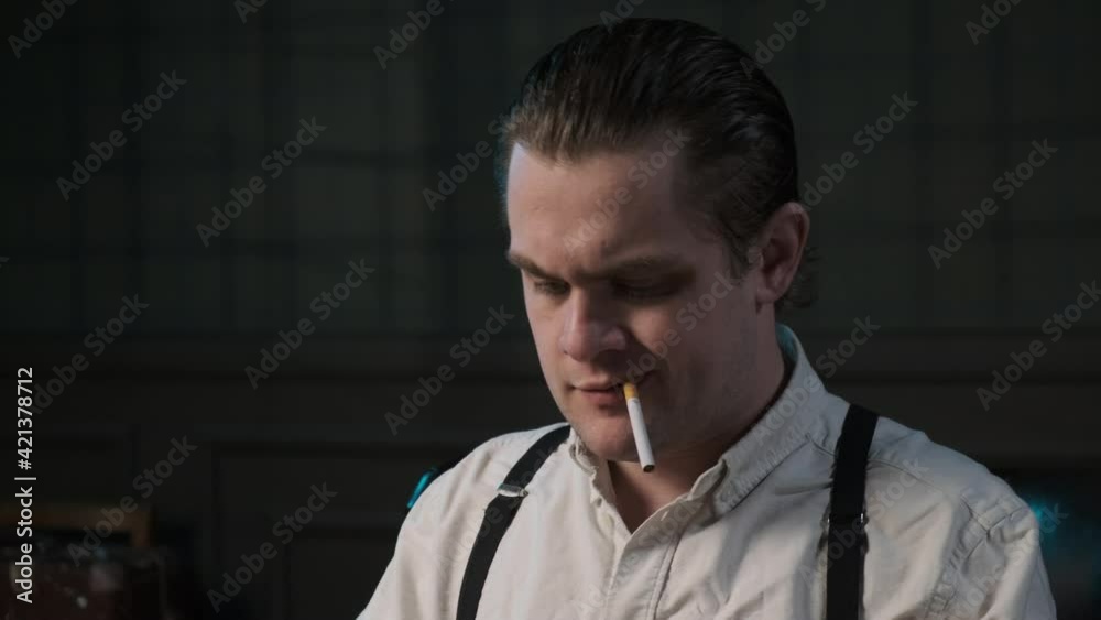 Close up look on face of real detective in white shirt and suspenders with cigarette in his teeth, prints something on typewriter. banker or mafia accountant clerk works. Close up look on face of real detective in white shirt and suspenders with cigarette in his teeth, prints something on typewriter. banker or mafia accountant clerk works.