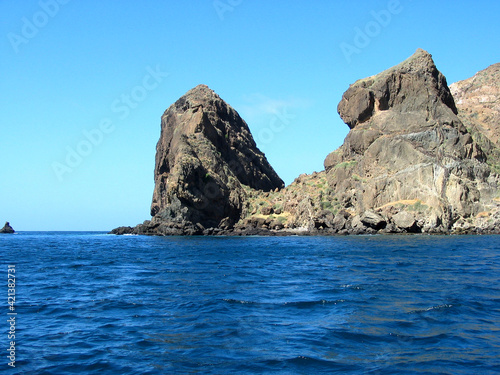 Rocky headland in Cabo Verde Islands, white sand, surf, blue water and rolling volcanic hills, Brava island...