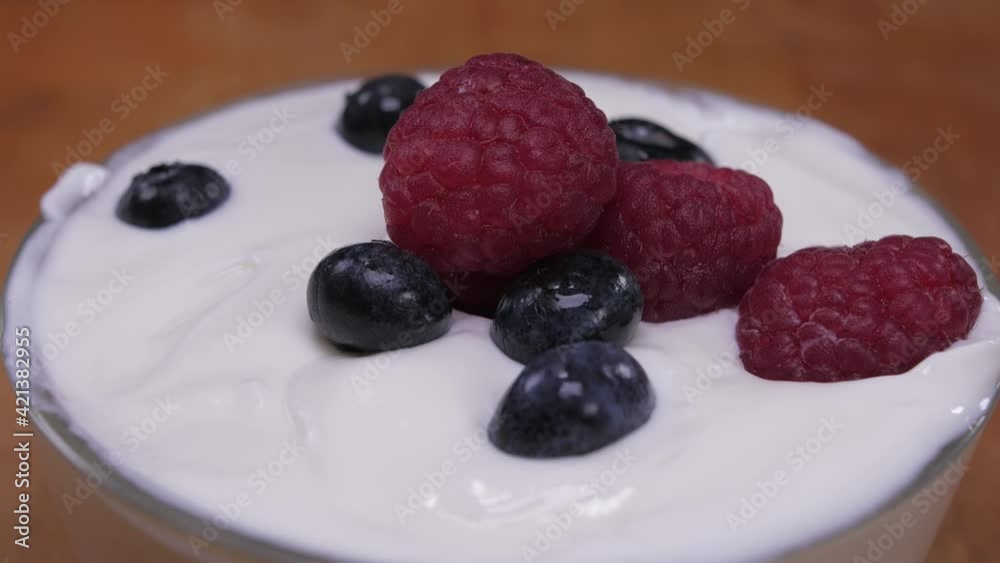 blueberries and raspberries falling in yogurt blueberries and raspberries falling in yogurt