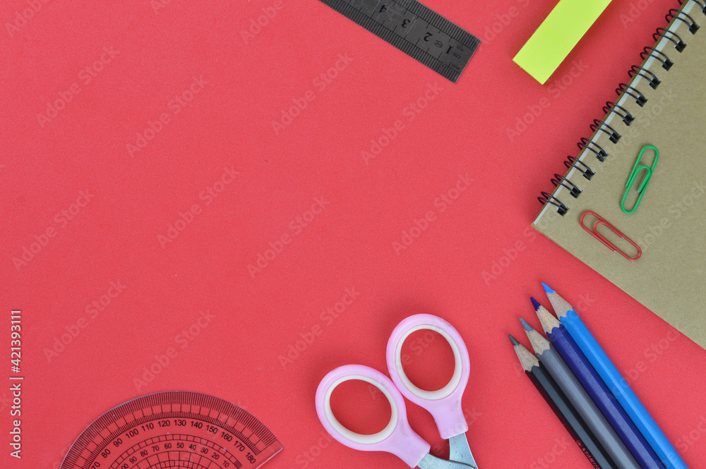 Flat lay view of stationery tools over red background with copy space.