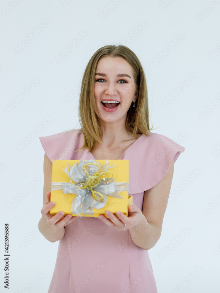 Portrait adult pretty caucasian woman blonde hair and pink dress holding present show a gift box and feels excited look feel happy in studio with white background Portrait adult pretty caucasian woman blonde hair and pink dress holding present show a gift box and feels excited look feel happy in studio with white background
