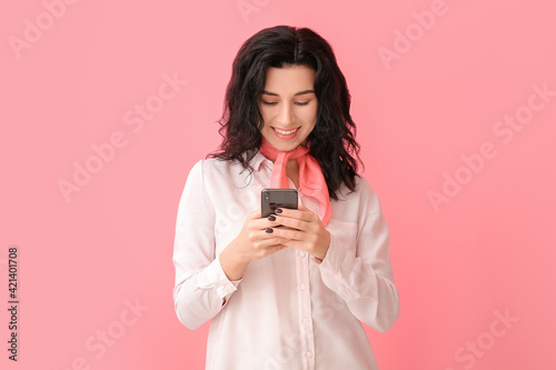 Beautiful young woman with mobile phone on color background
