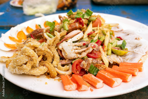 Papaya Salad on tray, which contains many ingredients such as shrimp, crab, cap, pork, and salted egg is a Thai food concept.