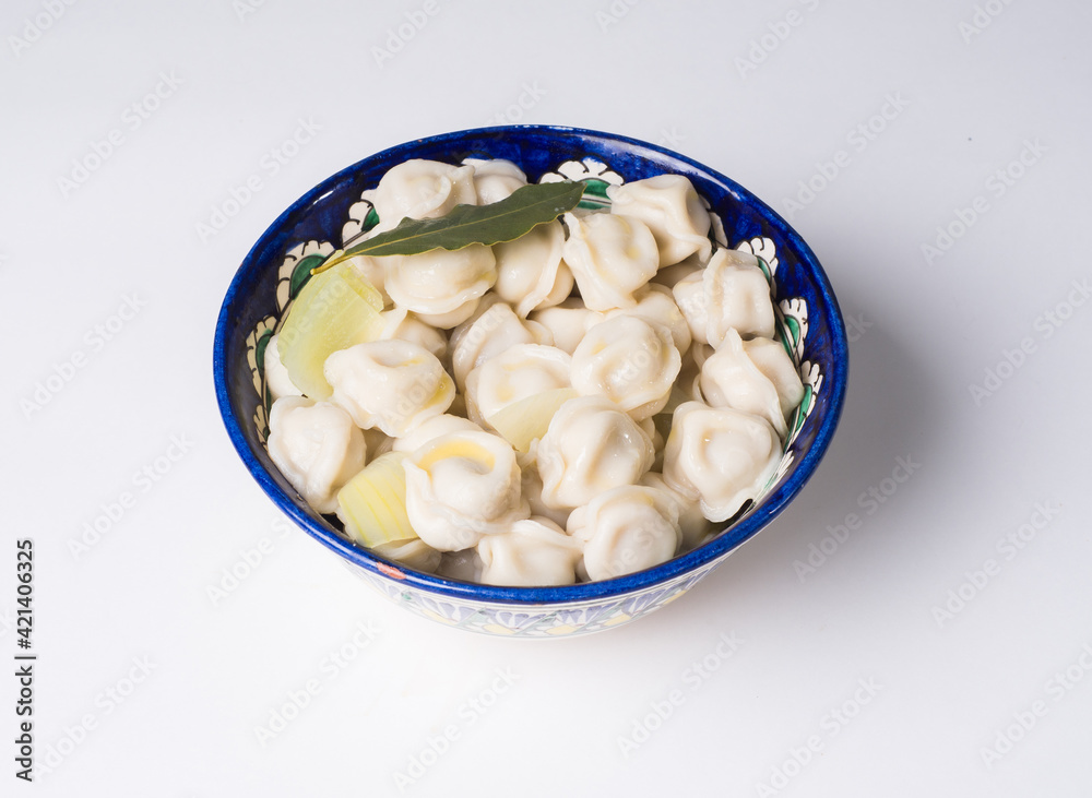 Dumplings in the national dish. Russian and Asian traditional cuisine. Studio photography Dumplings in the national dish. Russian and Asian traditional cuisine. Studio photography