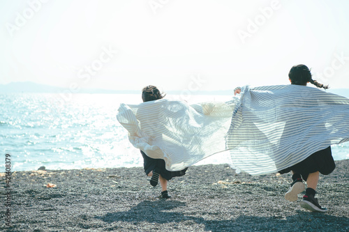 海で布を持って走る姉妹