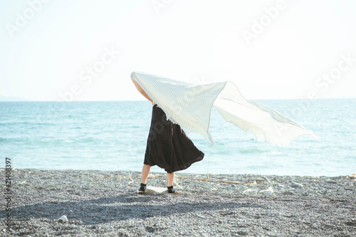 風になびく布と女の子