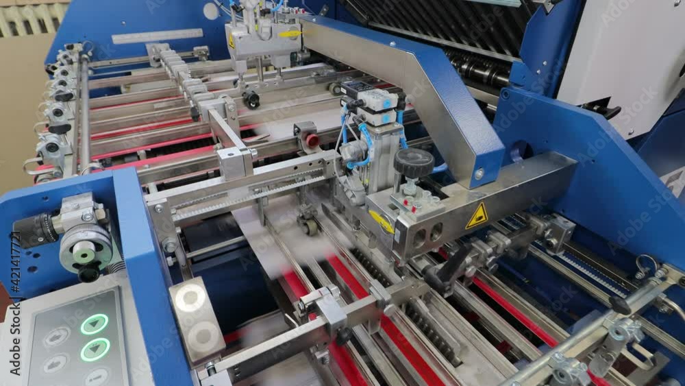 folding machine folds printed offset sheet as part of newspaper brochure in print house