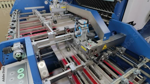folding machine folds printed offset sheet as part of newspaper brochure in print house