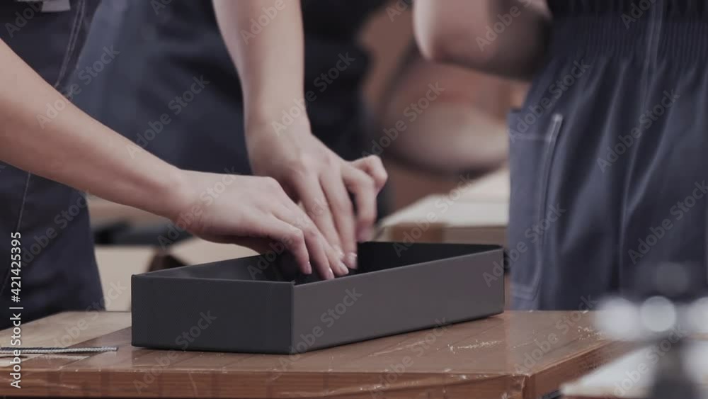 Close up worker hands laminated cardboard box. Modern factory of production cardboard box. Manufacture of cardboard boxes from paper. Enterprise for production package Close up worker hands laminated cardboard box. Modern factory of production cardboard box. Manufacture of cardboard boxes from paper. Enterprise for production package