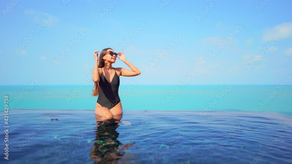 Modern Woman at Sunny Infinity Swimming Pool Border, Ocean Background. Modern Woman at Sunny Infinity Swimming Pool Border, Ocean Background.