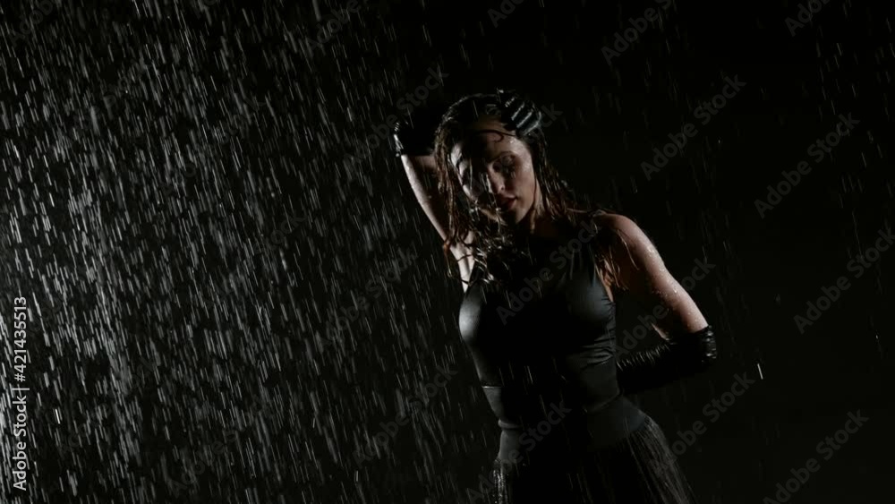 dancer in darkness, woman is dancing under rain, slow motion shot, waving her long wet hair dancer in darkness, woman is dancing under rain, slow motion shot, waving her long wet hair