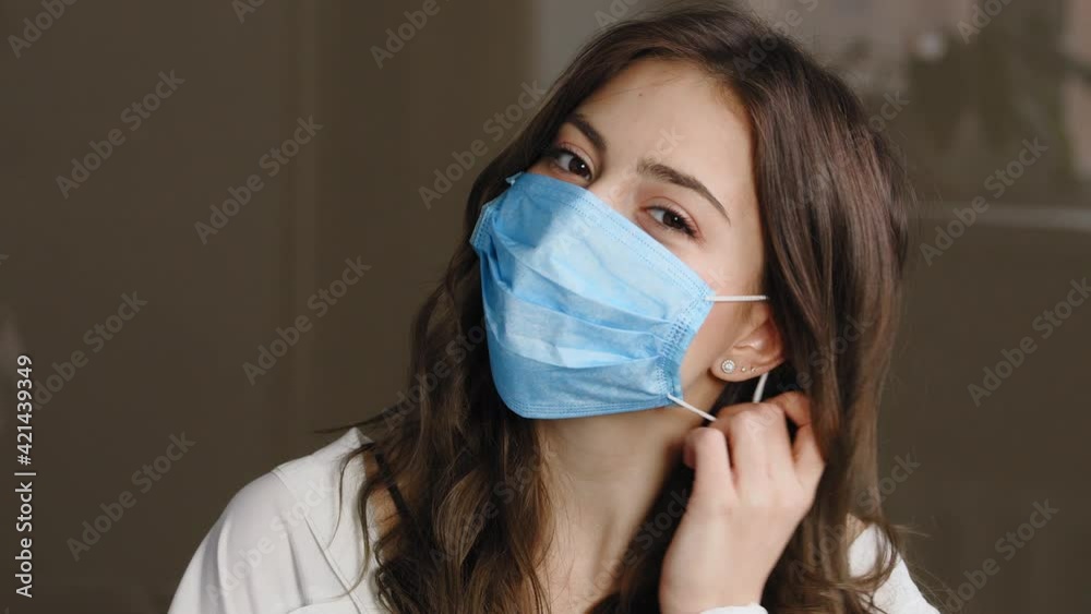 Portrait of beautiful brunette woman patient girl takes off protective medical mask from female face throwing away, smiles sincerely rejoices end of pandemic, enjoying air breathing, looking at camera Portrait of beautiful brunette woman patient girl takes off protective medical mask from female face throwing away, smiles sincerely rejoices end of pandemic, enjoying air breathing, looking at camera