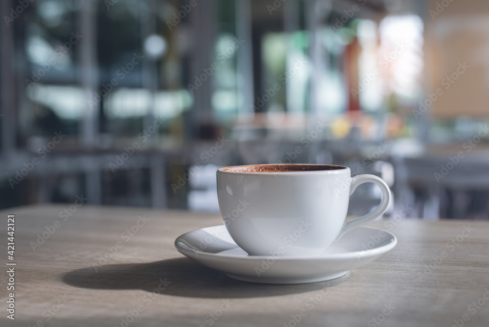 Cup of coffee on wooden table in coffee shop co-working space with nobody Cup of coffee on wooden table in coffee shop co-working space with nobody