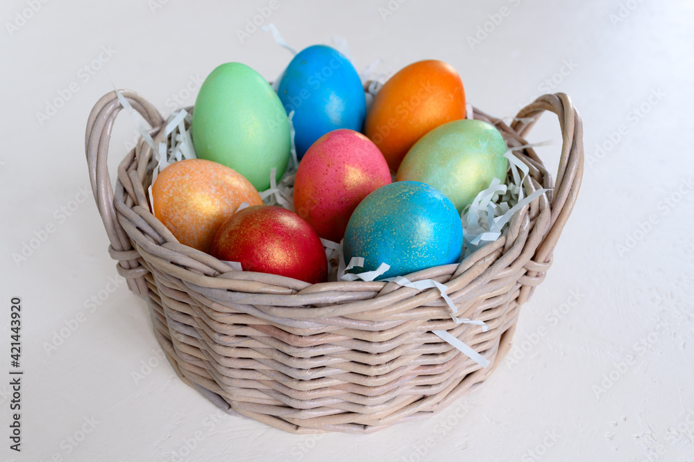 Painted chicken eggs in a wicker basket on a white table. Easter concept Handmade, creativity with children for decoration on easter Painted chicken eggs in a wicker basket on a white table. Easter concept Handmade, creativity with children for decoration on easter
