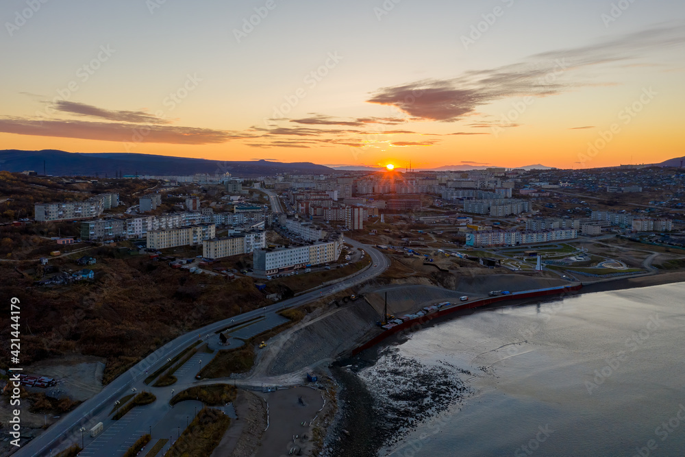 Morning aerial view of the city of Magadan. Top view of the port town. Sunrise over buildings and streets. Autumn city landscape. Magadan, Magadan region, Siberia, Far East of Russia.