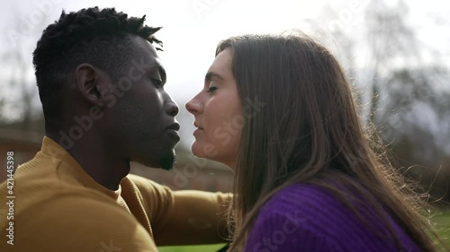 Young interracial couple kiss. Millennial lovers, African and white couple