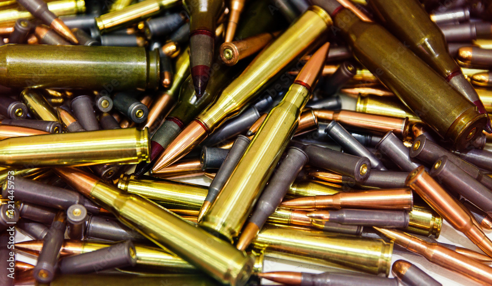 Pile of bullets with copper tips under a warm light. Close up of a lot