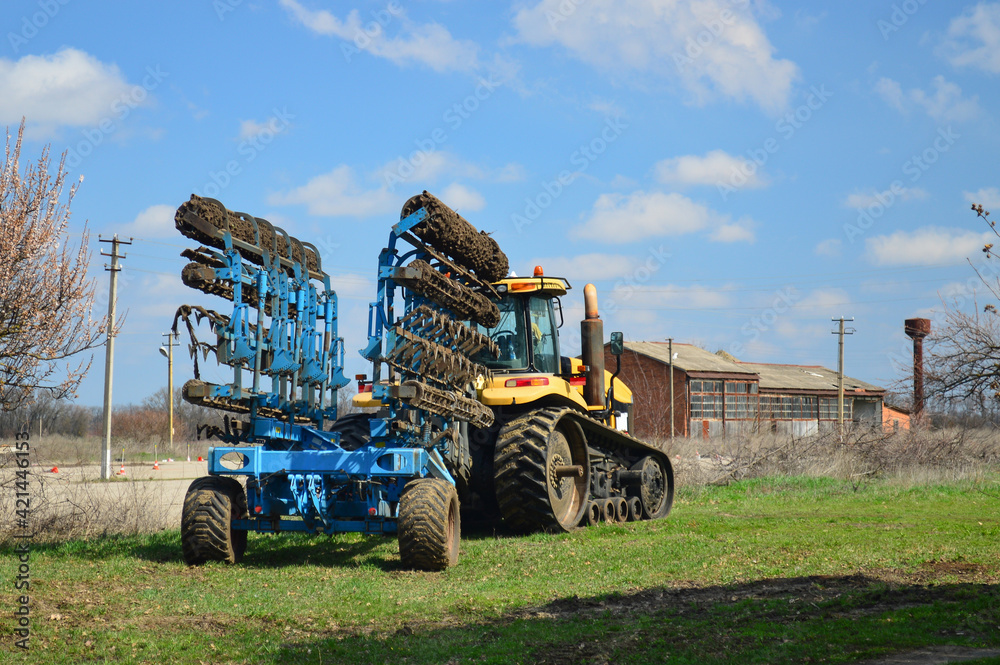 Obraz premium The tractor with modern farm equipment, cultivator or plow