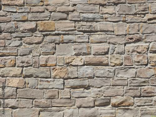 A wall with rough masonry of different sizes illuminated by sunlight. Not seamless texture