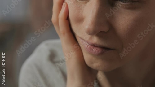 Close-up of a distressed woman with a toothache and her hand touching her face. The concept of dental disease