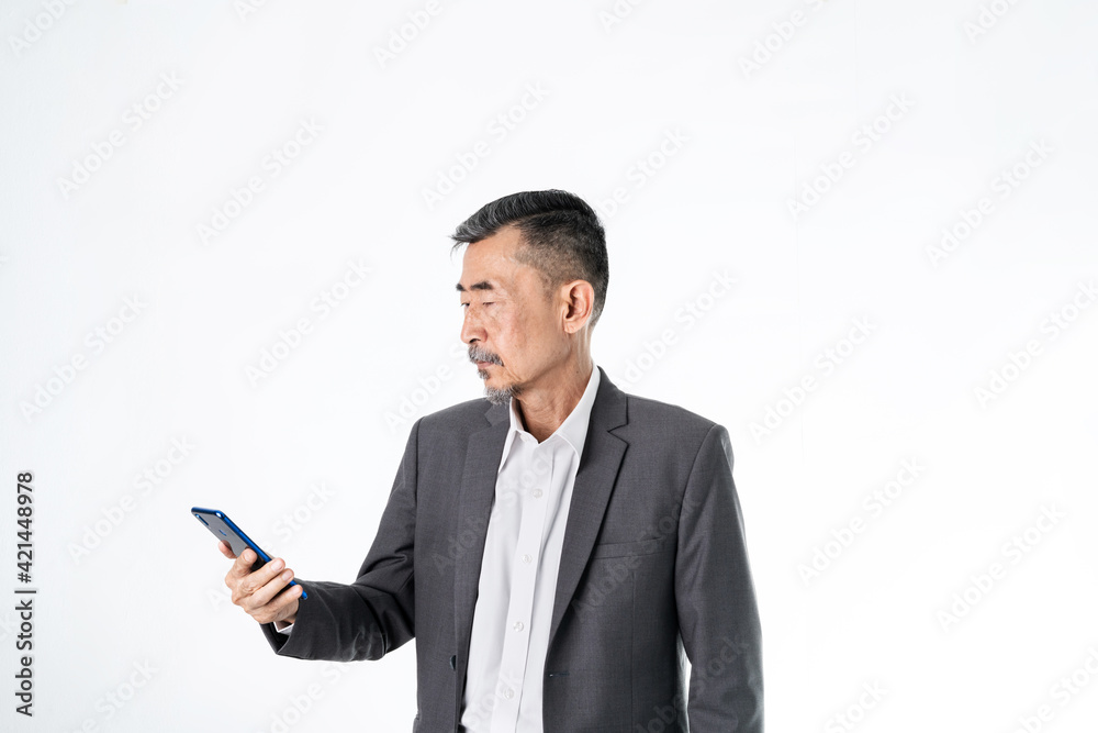An old Asian man in a grey suit has looked at the mobile phone need more clearly or has some online and technology questions. Set on A white background. Senior, alone retired and eye problem Concept
