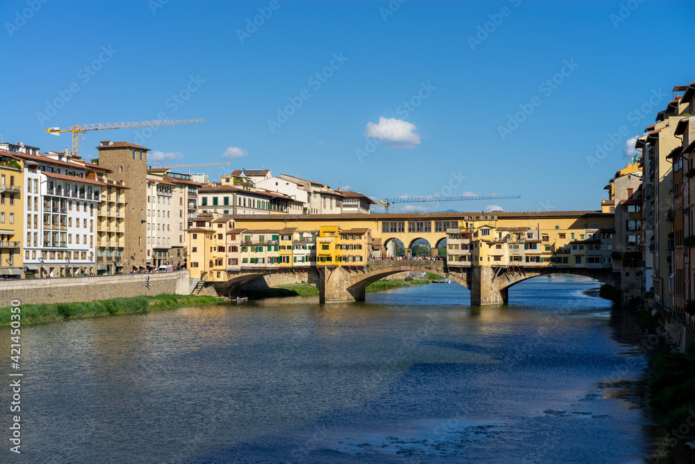 The Ponte Vecchio, the old bridge with its reflection in the Arno river  in Firenze, Florence, Italy