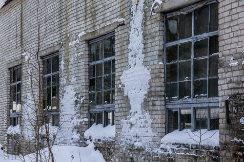 Frozen windows of an abandoned house in the North. Frozen building in severe frost.   Frost and snow on the walls and windows of an abandoned building  © Илья Юрукин