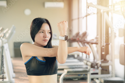 Young Asian healthy woman doing arm muscle stretching, warm up before exercising.