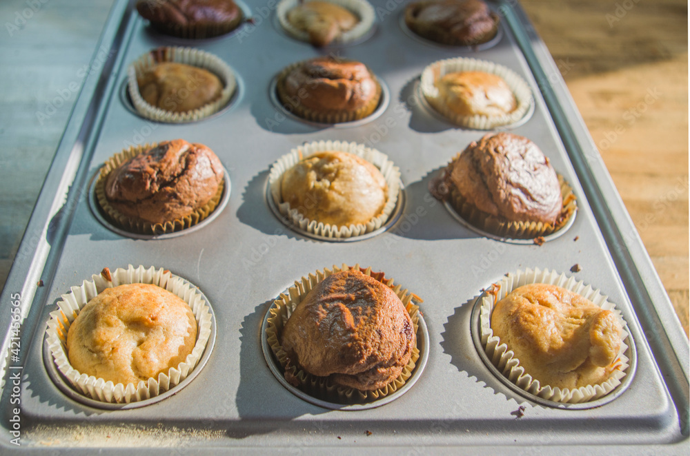 small vanilla and chocolate muffins illuminated by the morning light ready for breakfast