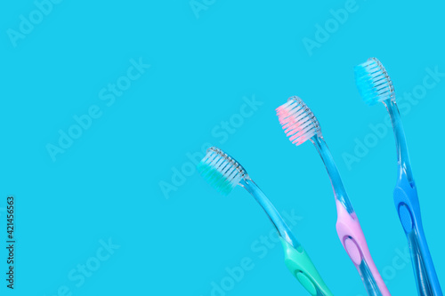 Toothbrushes on blue background with copy space.