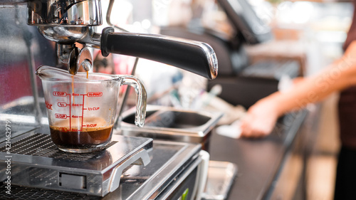 black coffee in measuring cup put on coffee maker