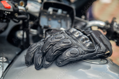 moto gloves. Motorcyclist arm protection.View of motorcycle accessories. Items included motorcycle helmet, keys and jacket. Motorcycle travel dream concept.