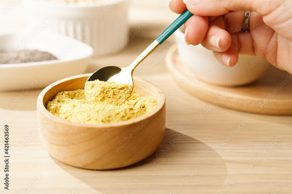 Nutritional yeast flakes in wooden bowl a great source of vitamins and minerals for vegan and plant-base diet contains amino acids, complete protein, Dairy free, Gluten free, Substitute, Superfoods. Nutritional yeast flakes in wooden bowl a great source of vitamins and minerals for vegan and plant-base diet contains amino acids, complete protein, Dairy free, Gluten free, Substitute, Superfoods.