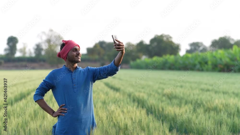 Young indian farmer using smartphone at wheat field Young indian farmer using smartphone at wheat field