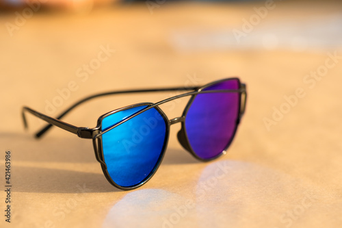 Cat eye sunglasses special model with blue lenses and black frame for ladies shoot in a summer day. Selective focus . High quality photo