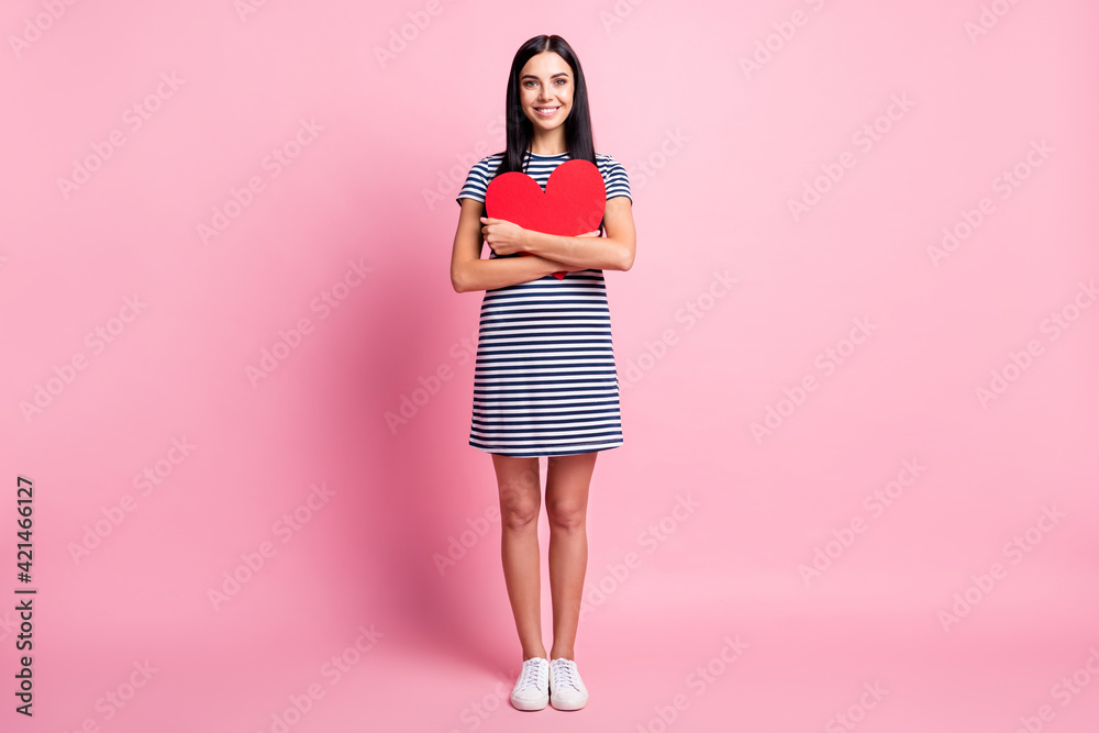 Full length body size view of affectionate lovely cheery fit girl holding in hands hugging heart isolated over pink pastel color background Full length body size view of affectionate lovely cheery fit girl holding in hands hugging heart isolated over pink pastel color background