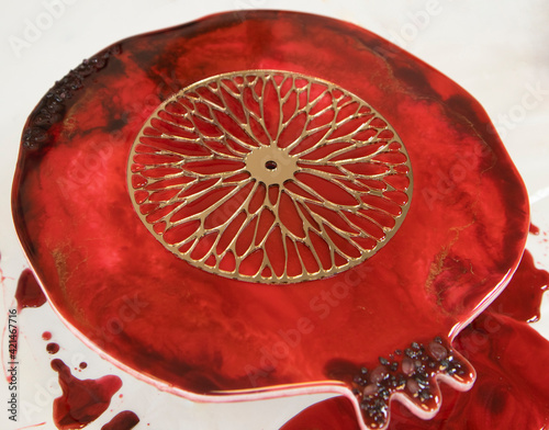 craft, pomegranate clocks with epoxy resin in a bright room, on a white table, in the afternoon. Master class, hobby, rest, new hobbies, creative profession. Epoxy painting photo