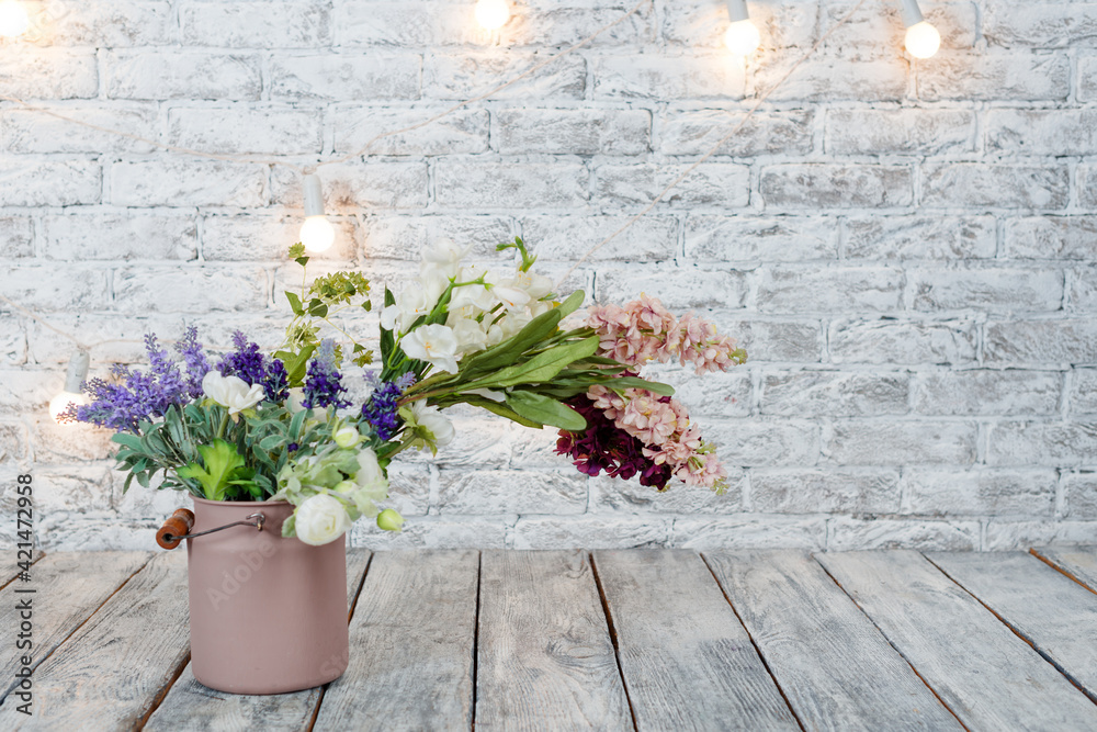 Flowers with light bulbs on white brick background with wooden floor.