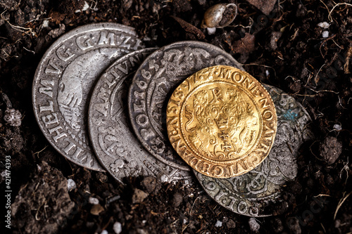 Closeup view of medieval European gold and silver coins.Old Polish coins.Zygmunt III Waza.Ancient gold and silver coins.Numismatics.silver coins covered in dirt.Antikvariat.