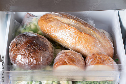 Frozen bread in the home freezer. Frozen bread: ciabatta, hamburger buns, loaf photo