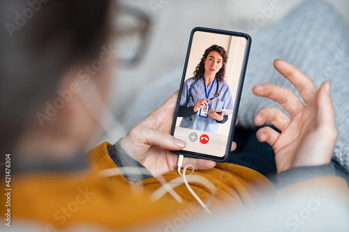 Fototapeta Woman doing video call with doctor