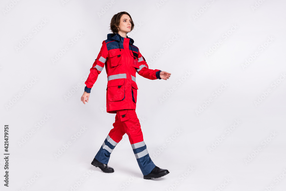 Full size profile photo of serious nice brunette lady go look wear uniform isolated on grey color background Full size profile photo of serious nice brunette lady go look wear uniform isolated on grey color background