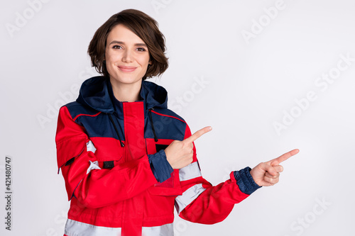 Photo of optimistic nice brunette lady point empty space wear uniform isolated on grey color background photo