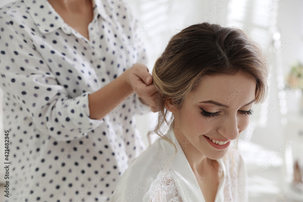 Professional stylist making wedding hairstyle for bride in salon Professional stylist making wedding hairstyle for bride in salon