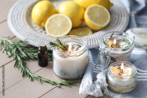 Natural homemade mosquito repellent candles and ingredients on wooden table photo