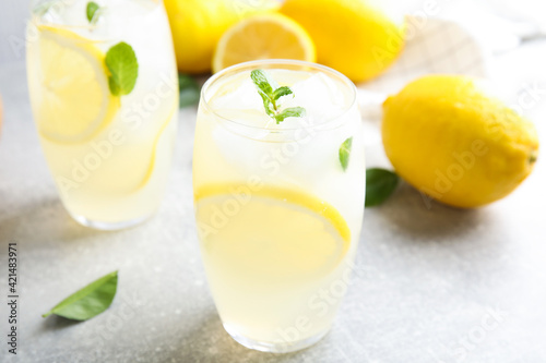 Glasses of cold lemonade on grey table, closeup